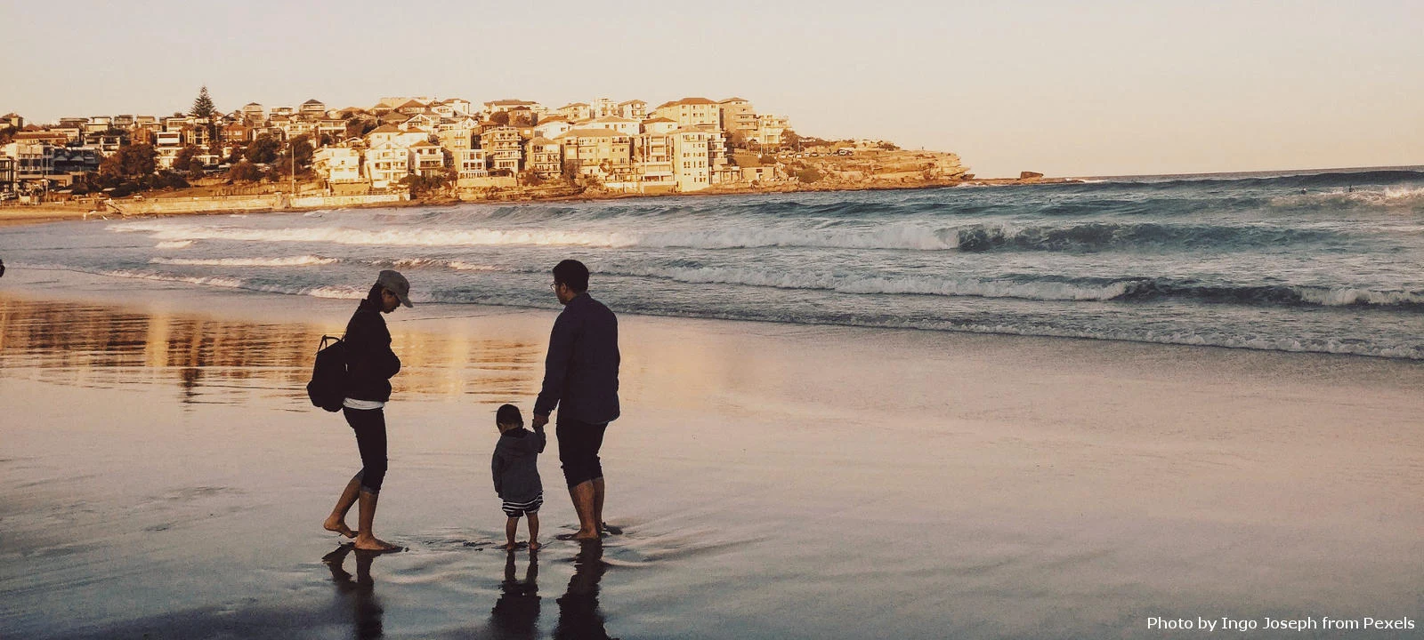 Man and woman with child by the sea at dawn