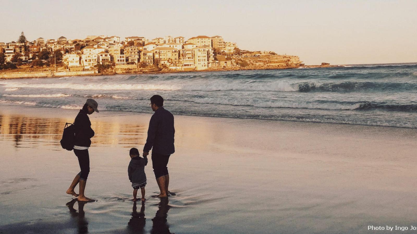 Man and woman with child by the sea at dawn